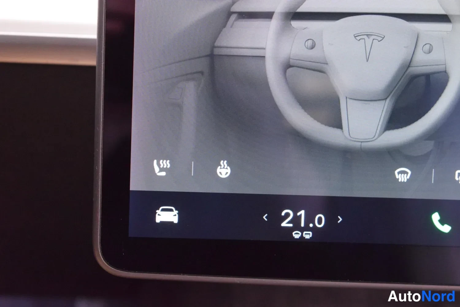 Muu: Tesla-näytön kulma, jossa Lämmitys-asetukset: istuinten ja ohjauspyörän lämmityksen kuvakkeet sekä lämpötilan säätö 21,0 astetta.
