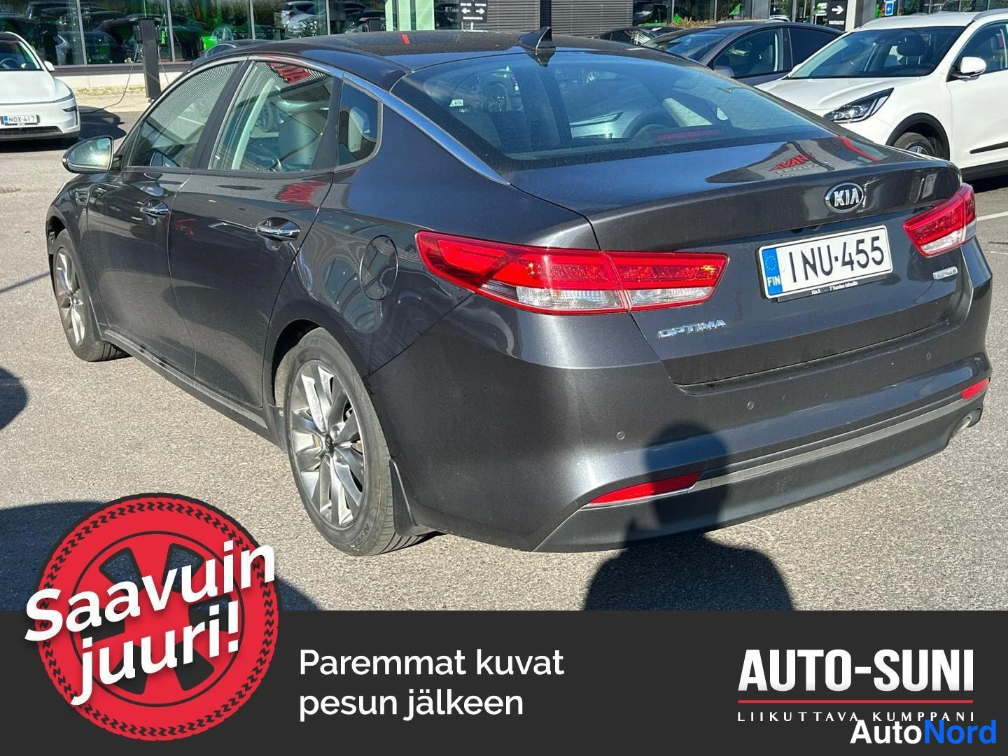 Takaviisto: Kia Optima -sedanin takakulmakuva vasemmalta, tummanharmaa kori, rekisteritunnus, Optima-teksti takaluukussa