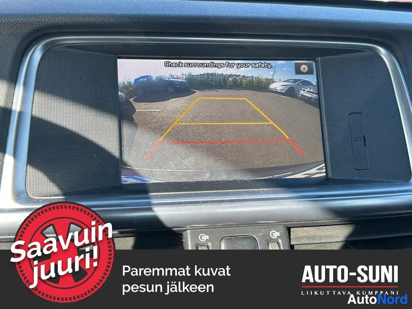 Sivulta: Kesk näytöllä peruutuskameran kuva ja opasteteksti Check surroundings for your safety