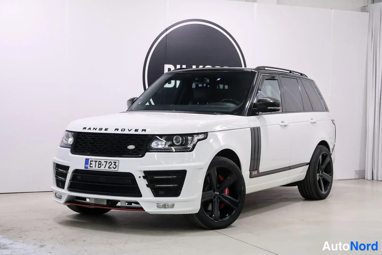Etuviisto, nokka vasemmalle: Valkoinen Range Rover etukulmasta oikealta, rekisteritunnus.