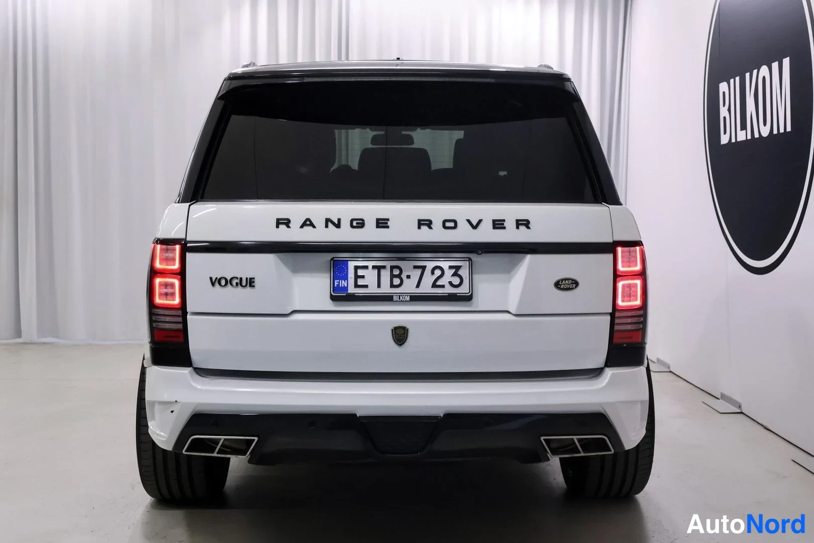 Takaa: Valkoisen Range Roverin perä suoraan takaa, tekstit RANGE ROVER ja VOGUE, rekisteritunnus.