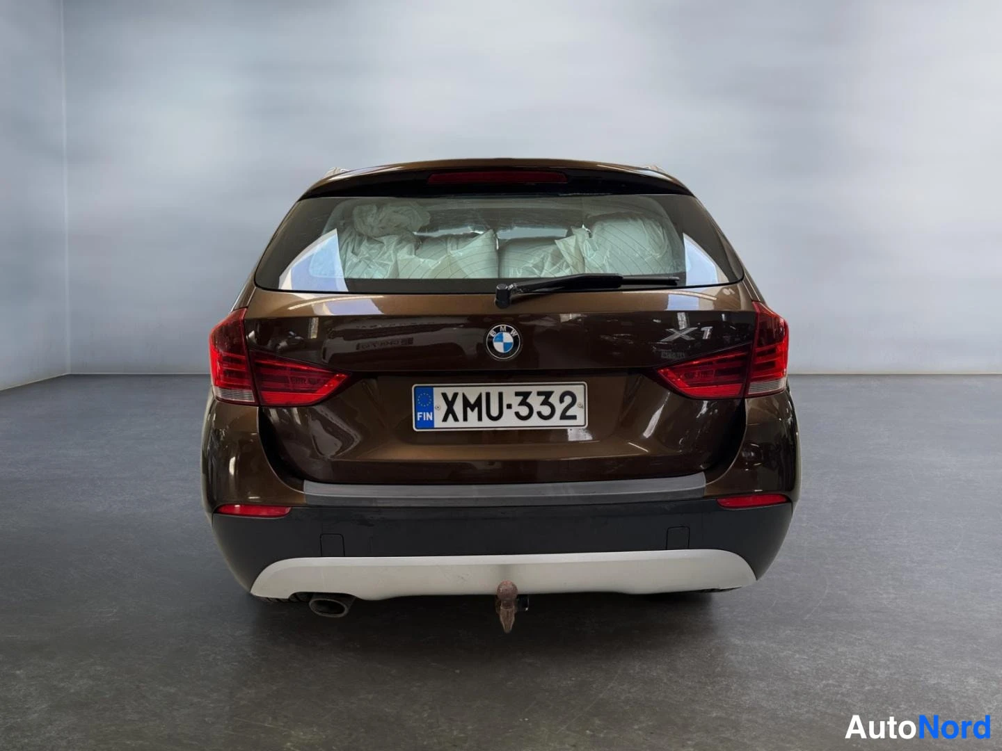 Takaa: BMW X1 suoraan takaa, rekisteritunnus ja X1-merkintä takaluukussa.