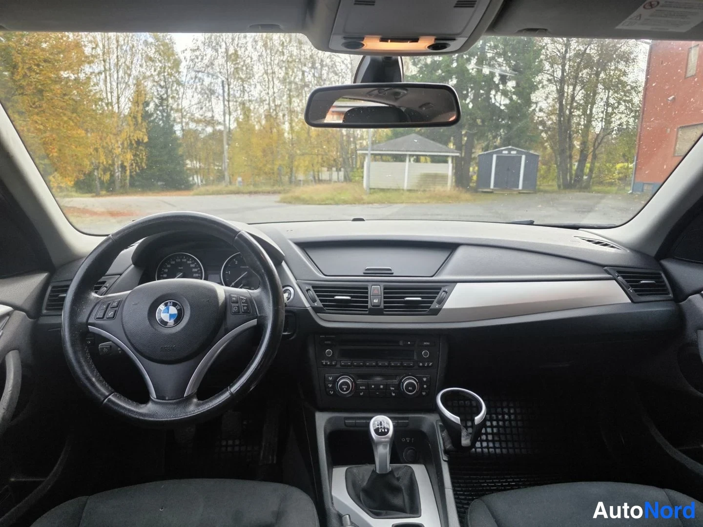 Yksityiskohta: Auton sisätila: BMW-ohjauspyörä, vaihtaja ja kojelaudan näkymä tuulilasin läpi.