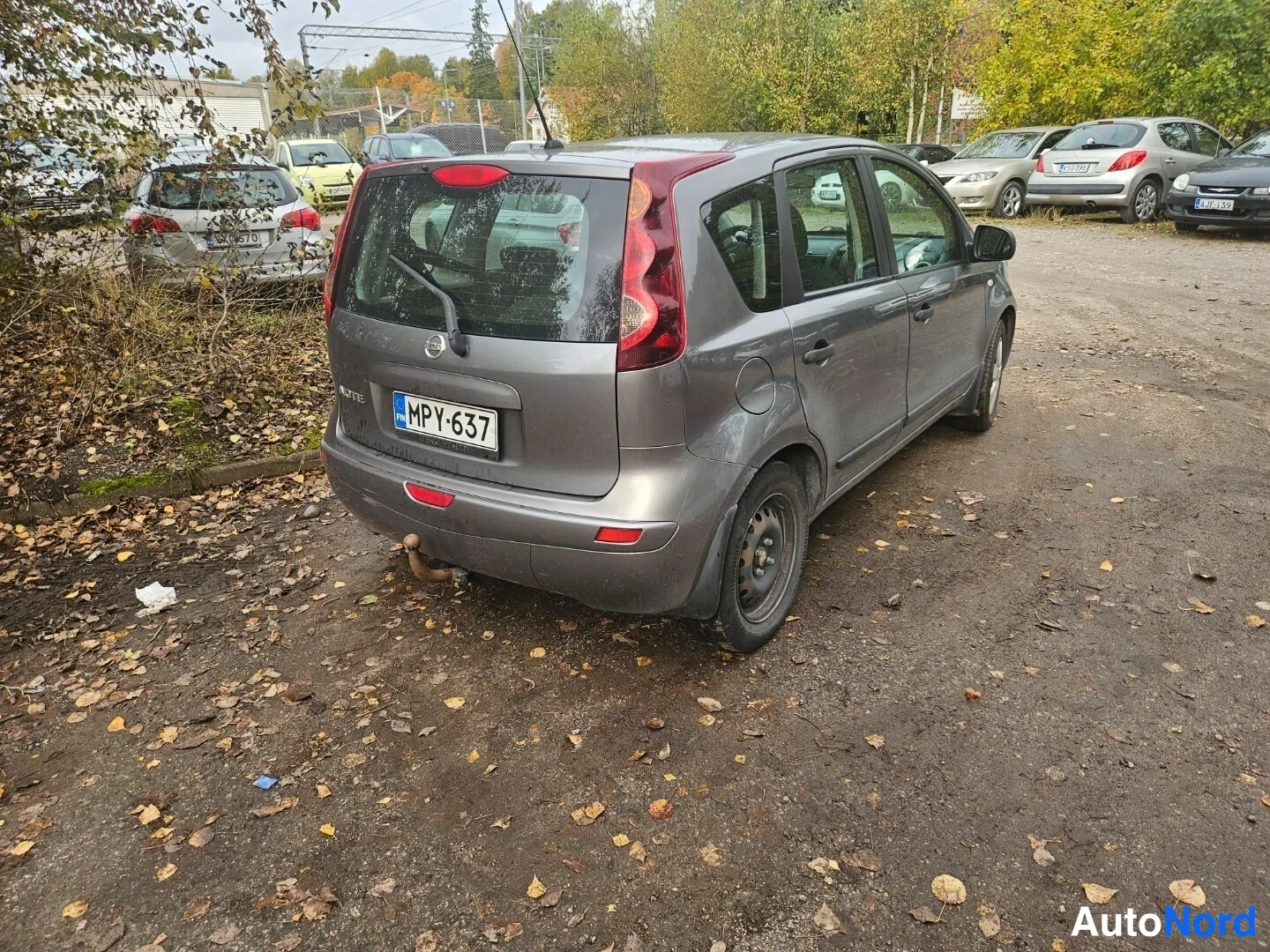 Takaviisto: Harmaan Nissan Noten takakulma vasemmalta, takavalot, -kilpi ja takapyörän kenkä näkyvissä.