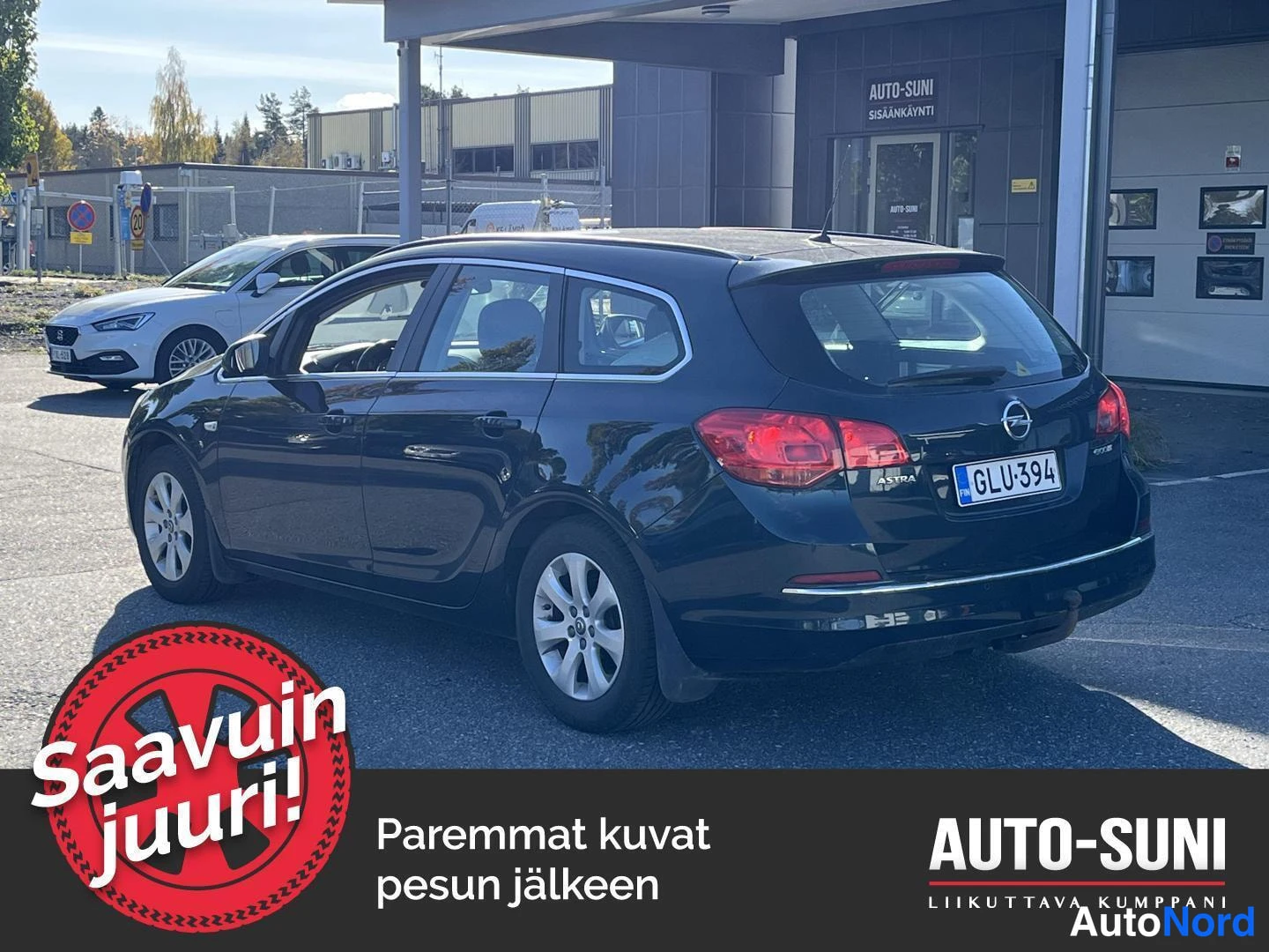Takaviisto: Opel Astra Sports Tourer -farmari tummansinisenä tai tummanvihreänä takakulmasta oikealta, rekisteritunnus.