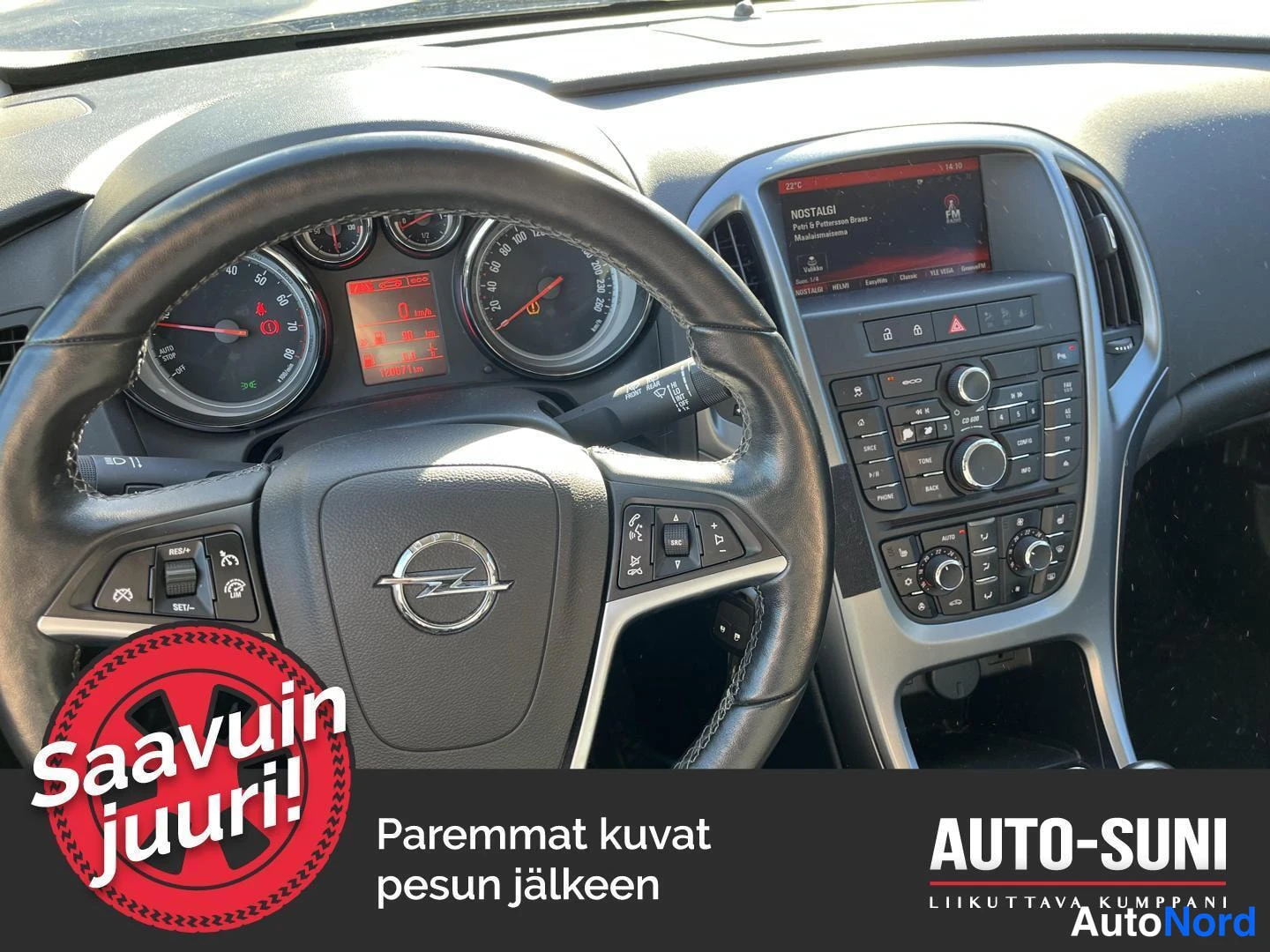 Muu: Auton kojelauta ja ohjauspyörä Opel-merkillä, mittaristo ja radio-näyttö näkyvät.