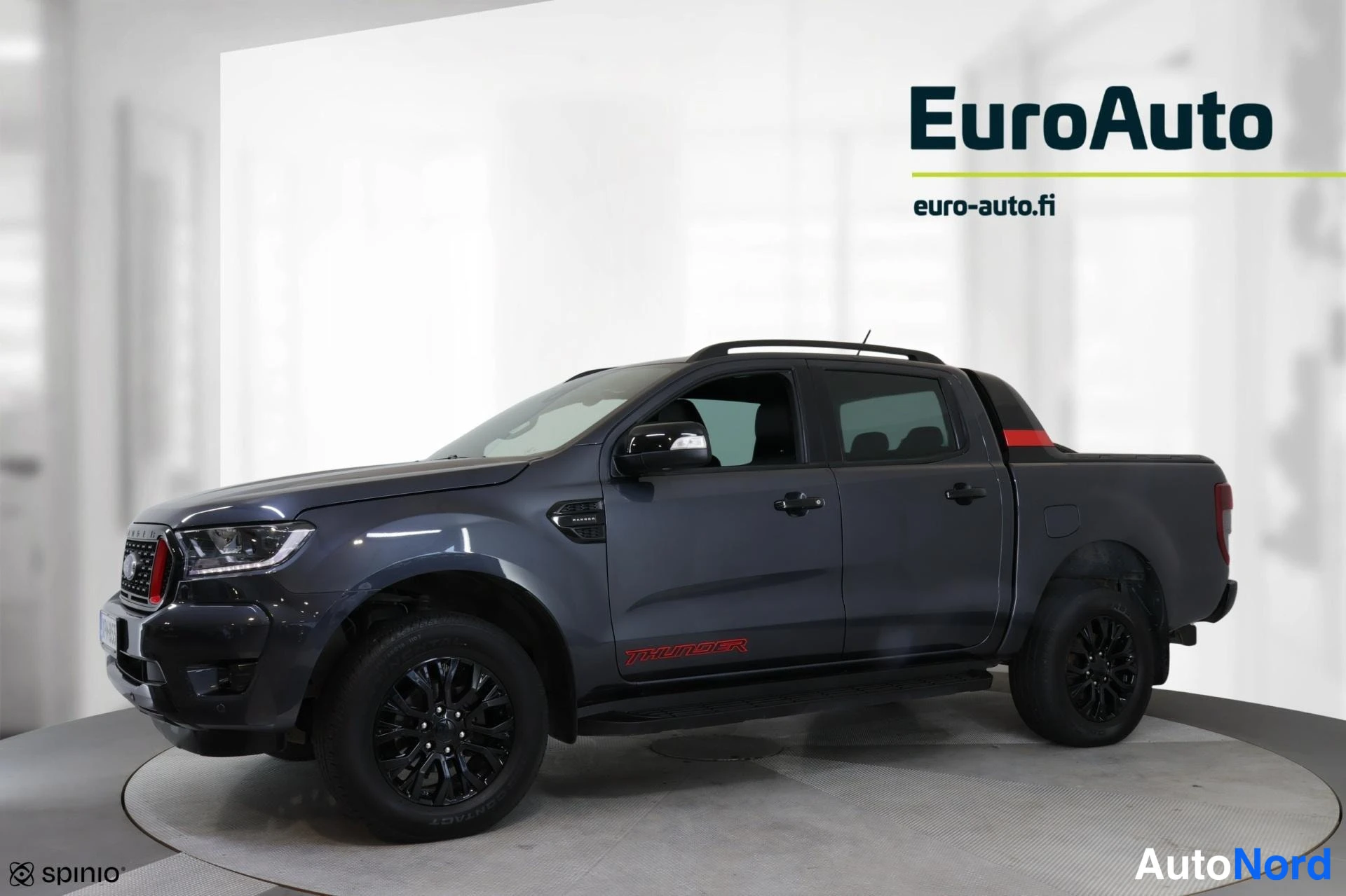 Etuviisto, nokka vasemmalle: Ford Ranger -nutta-auto vasemmasta sivukulmasta, tummanharmaa koripaneeli, mustat kevytmetallivanteet ja Thunder-koristekuvio kyljessä.