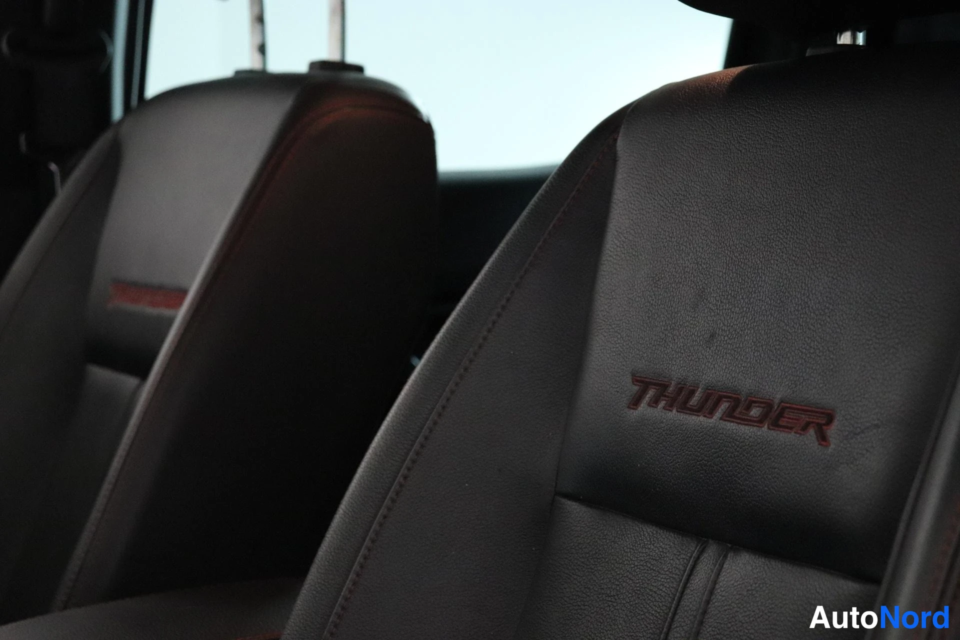 Muu: Ford Rangerin etumistuinten selkänojat tummalla nahkaverhoilulla; selkänojassa punainen THUNDER-kirjailu