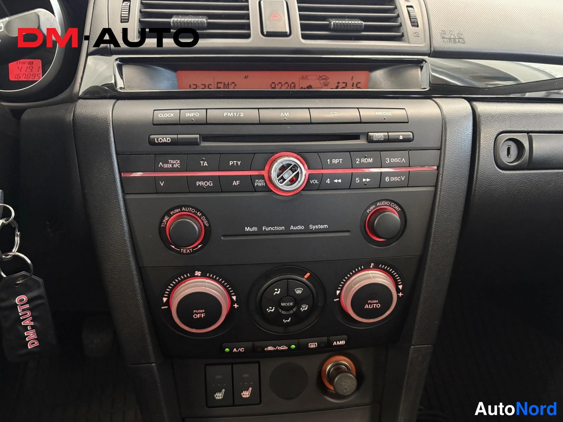 Yksityiskohta: Kojelaudan keskustan lähikuva: radio/CD-yksikkö ja automaattinen ilmastointipaneeli A/C- ja heated-lisapainikkeineen.