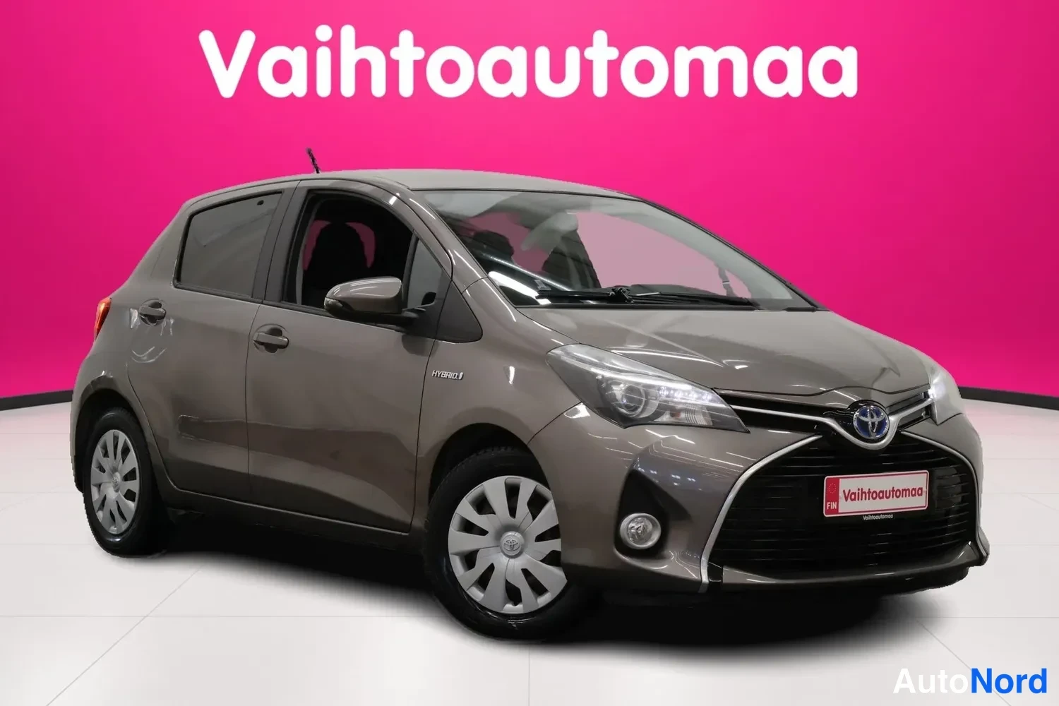 Etuviisto, nokka oikealle: Toyotan etukolmisureunus oikealta, harmaanruskea crossover-hatchback pinkinäköisessä studioon.