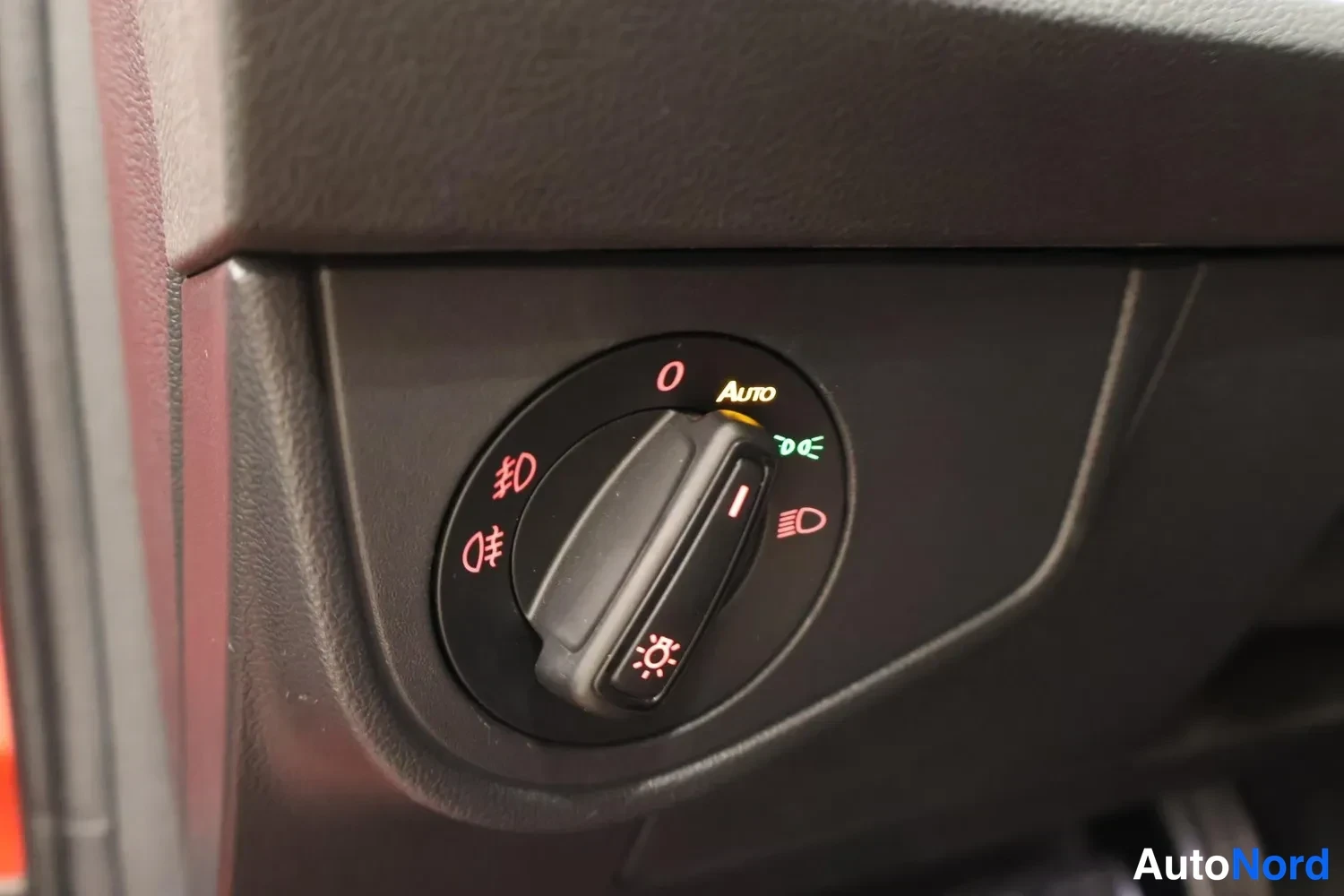 Muu: Lähikuva kojelaudan valokytkimestä, jossa Asento Auto-merkinnät ja sumuvalojen symbolit.