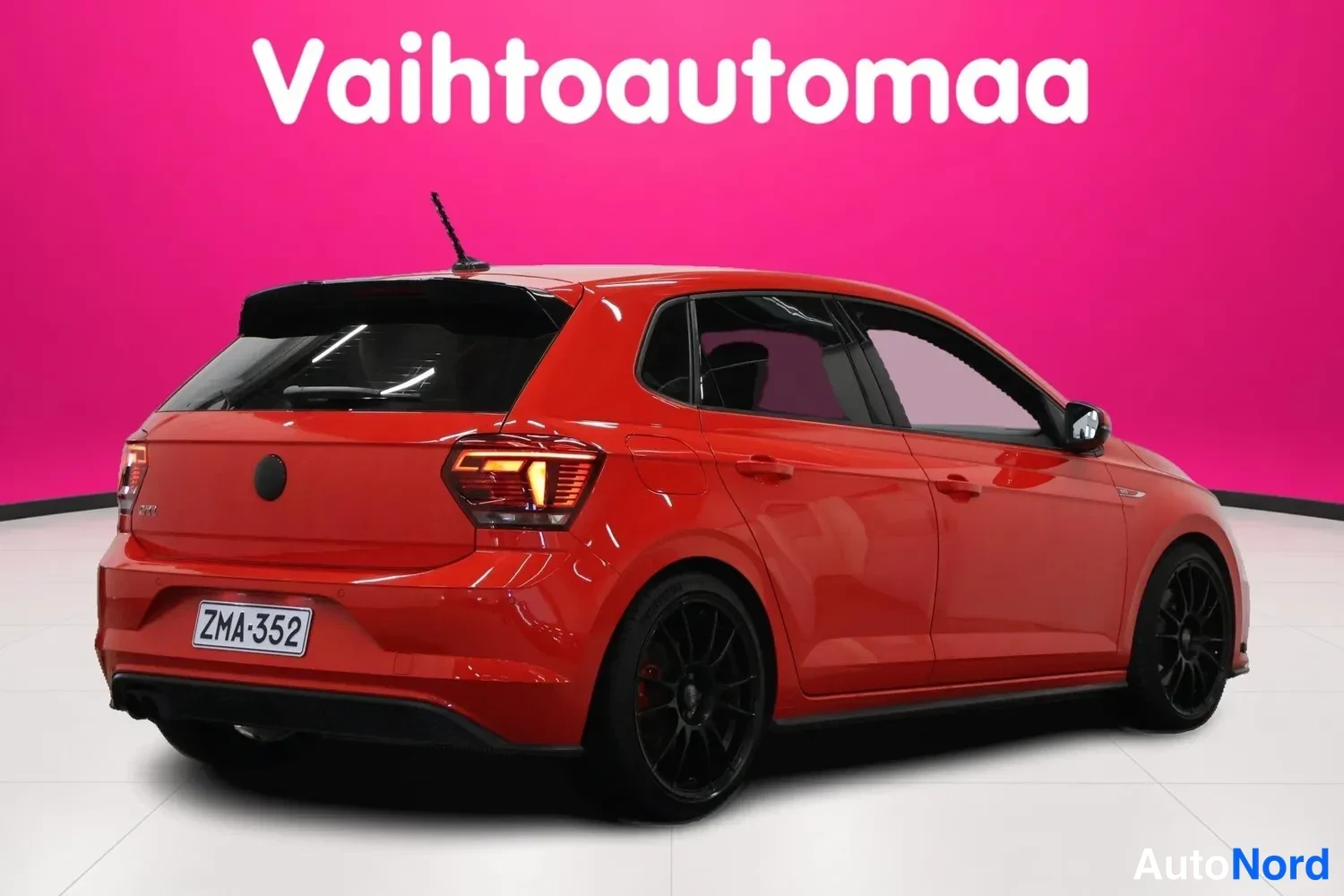 Takaviisto: Auton takakulmanäkyva kuva, punainen viistoperä auto mustilla vanteilla rekisterikilvellä
