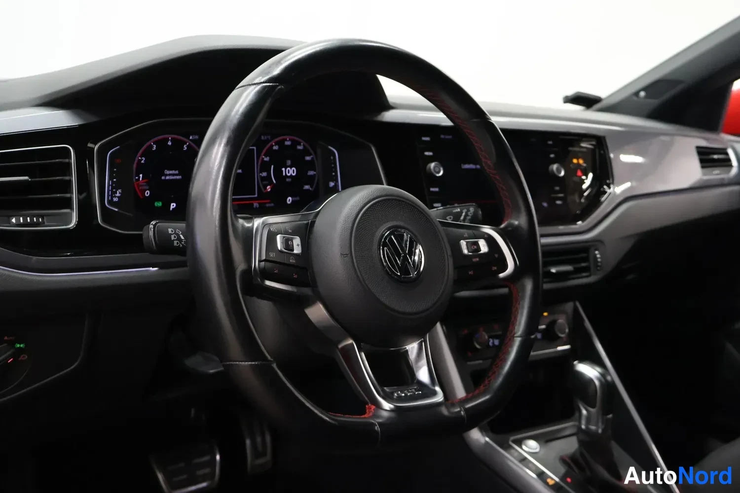 Muu: Volkswagen-ohjauspyörä punaisillaommelluksilla, digitaalinen仪表tausta ja keskinäyttö näkyvät.