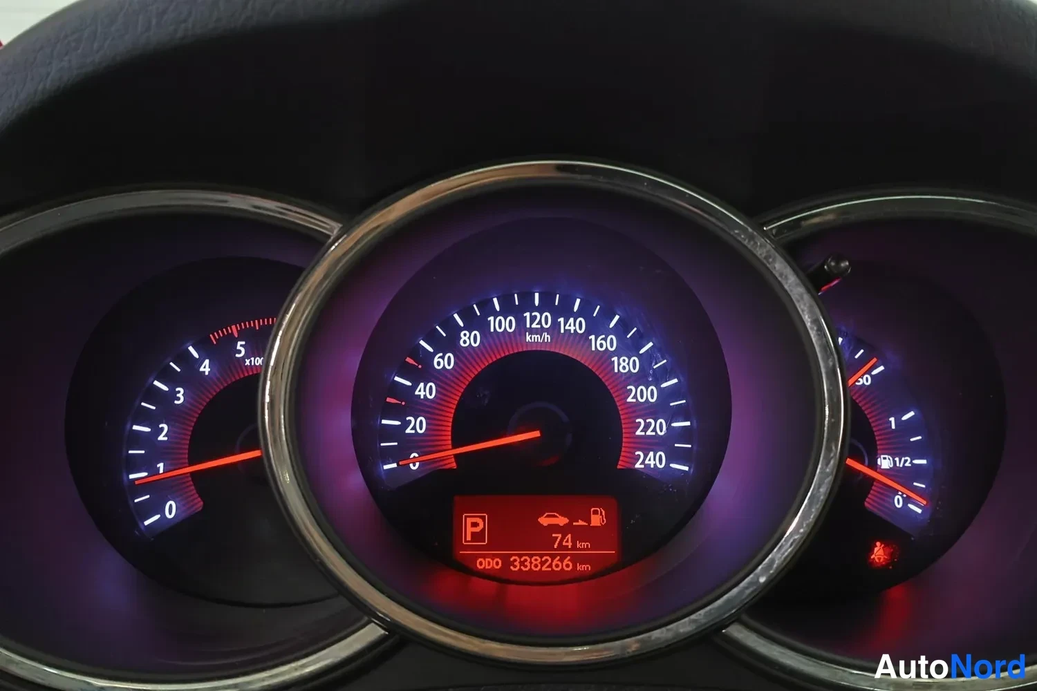 Muu: Mittariston keskimmäinen nopeusmittari, näyttö ilmoittaa ODO 338266 km ja polttoainemittarin lukeman 74 km.