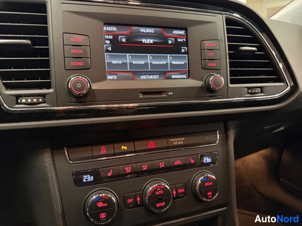 Muu: Auton kojelaudan keskiosan lähikuva: kosketusnäyttö radiovirkailijalla (YLELEX), ympärillä RADIO-, MEDIA-, SOUND-, PHONE-, CAR- ja MENU-napit, alla kaksivyöhykk