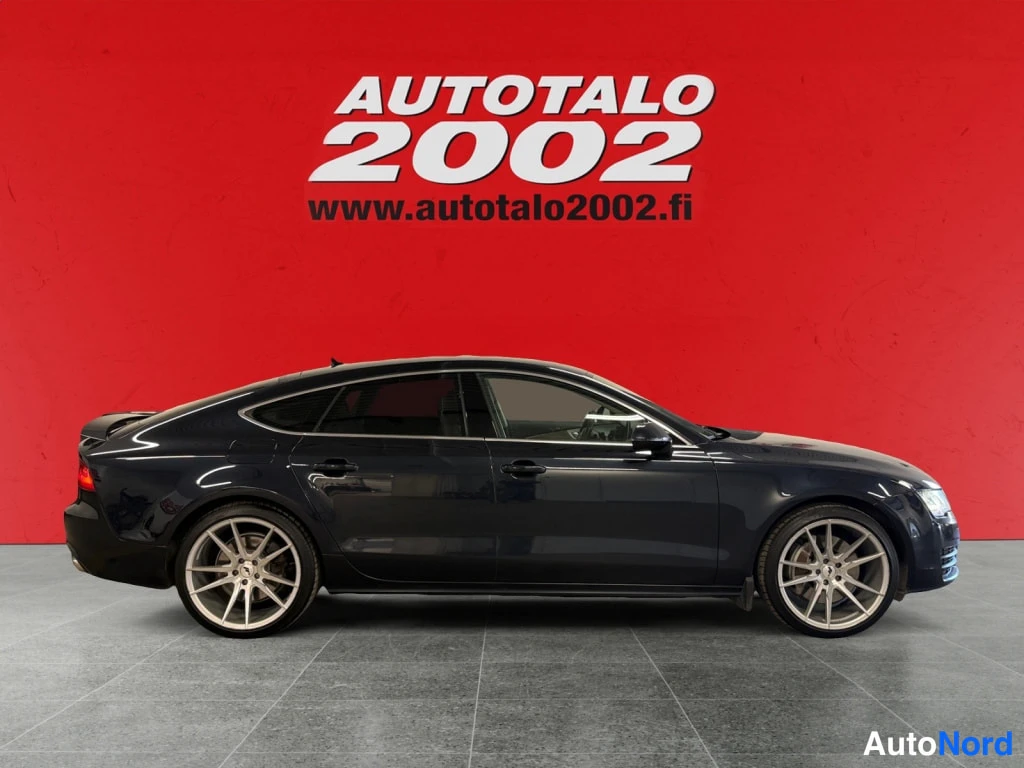 Sivulta: Audi A7, tummansininen koriväri, kylkinen kuva — kori tummansininen, kliinisesti väri jakaa otsakkeen takaa alasastutaan.
