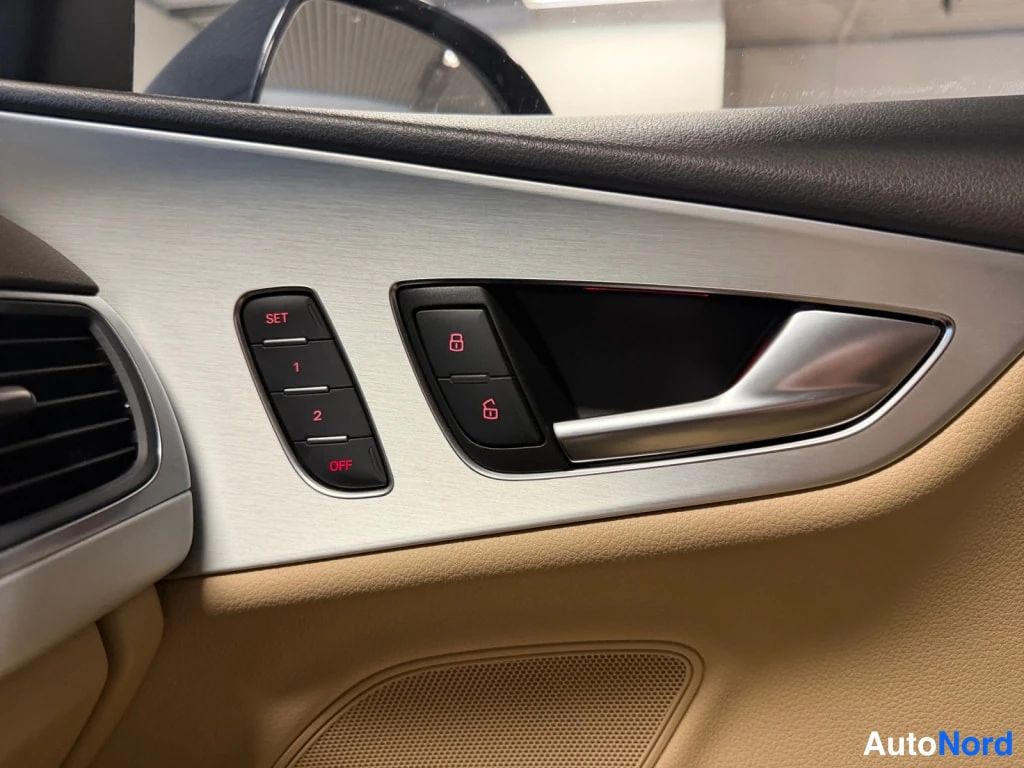 Muu: Audi A7:n oven sisäpaneeli: muistipainikkeet SET, 1 ja 2, lukituksen ohjaus ja hiilikuidusta ova ovi harjastakissa.