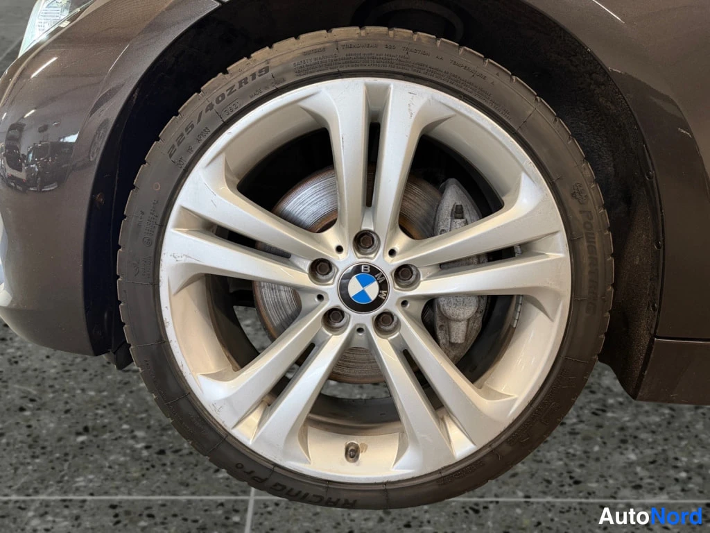 Yksityiskohta: BMW-ympyrämerkki alumiinivanteessa, renkaan sivuseinässä teksti 225/40 ZR19 ja merkintä RACING PRO.