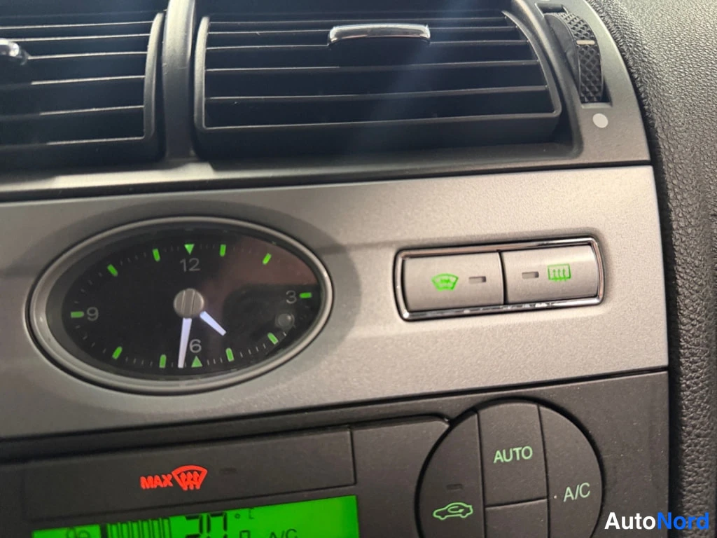Yksityiskohta: Kojeisteen lähikuva: analoginen kello, ajastinnapit, ESP- ja MAX-defrost-merkit sekä automaattisen ilmastoinnin AUTO- ja A/C-napit.