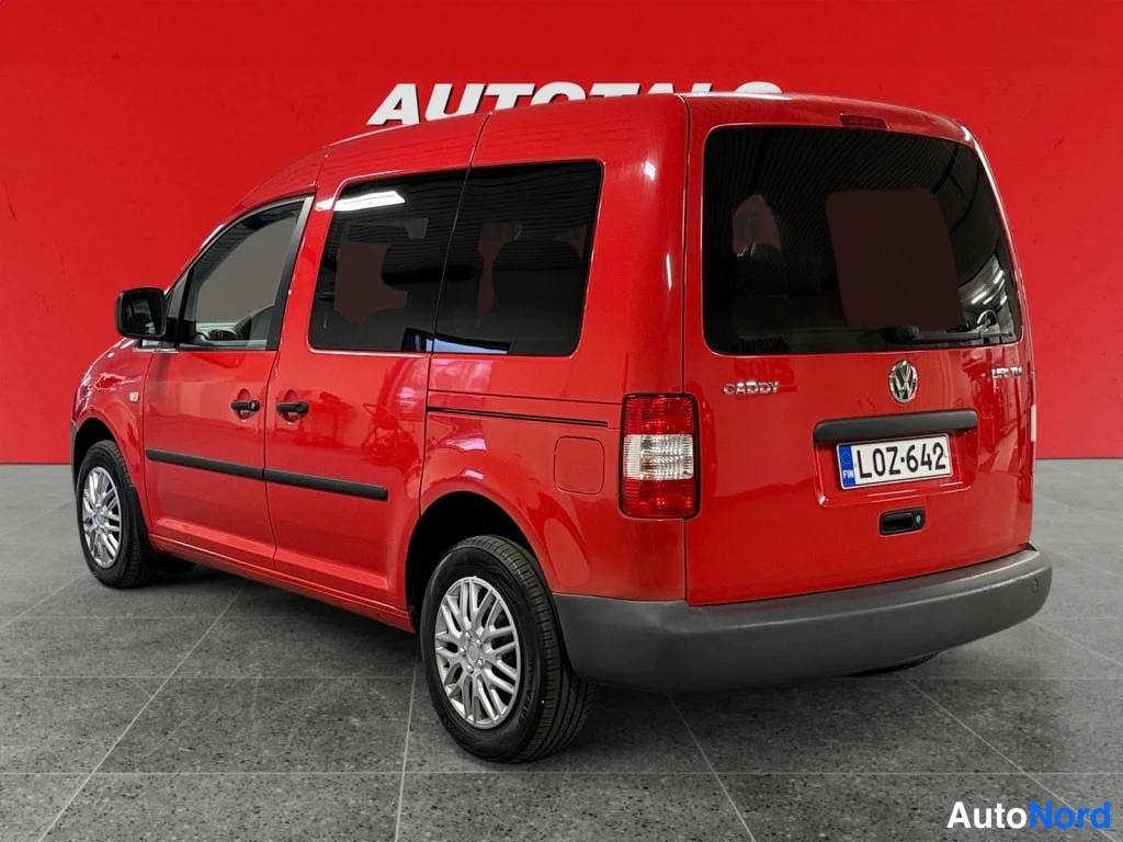 Takaviisto: Punaisen Volkswagen Caddy -auton takaosa ja vasen sivu kolmelta neljäsosaa takaa kuvattuna, rekisterikilpi.