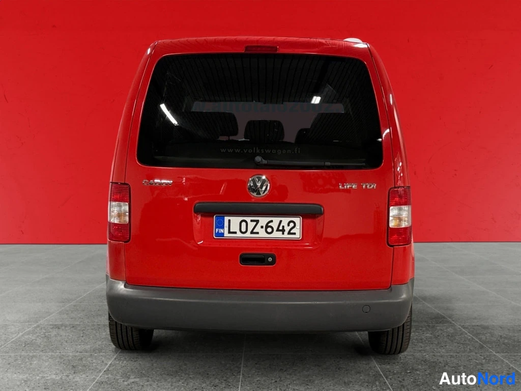 Takaa: Punaisen Volkswagen Caddy -auton perä suoraan takaa, rekisterikilpi, Caddy- ja Life TDI -merkit näkyvissä.