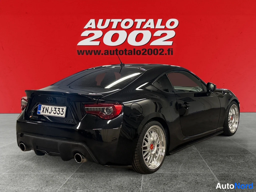 Takaviisto: Mustan Toyota GT86 -coupén takakulma, takavalot ja kaksoispakoputket näkyvissä, rekisteritunnus.