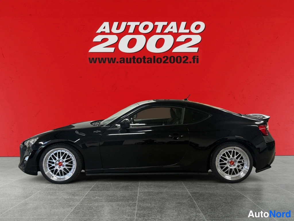 Sivulta: Mustan Toyota GT86:n sivuprofiili, keulakko vasemmalle, hopeiset vanteet.