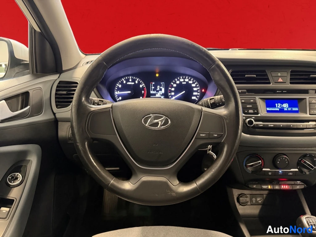 Muu: Ohjaamo Hyundai-merkillä: ohjauspyörä, analogiset mittarit, radio ja A/C-napit näkyvät.