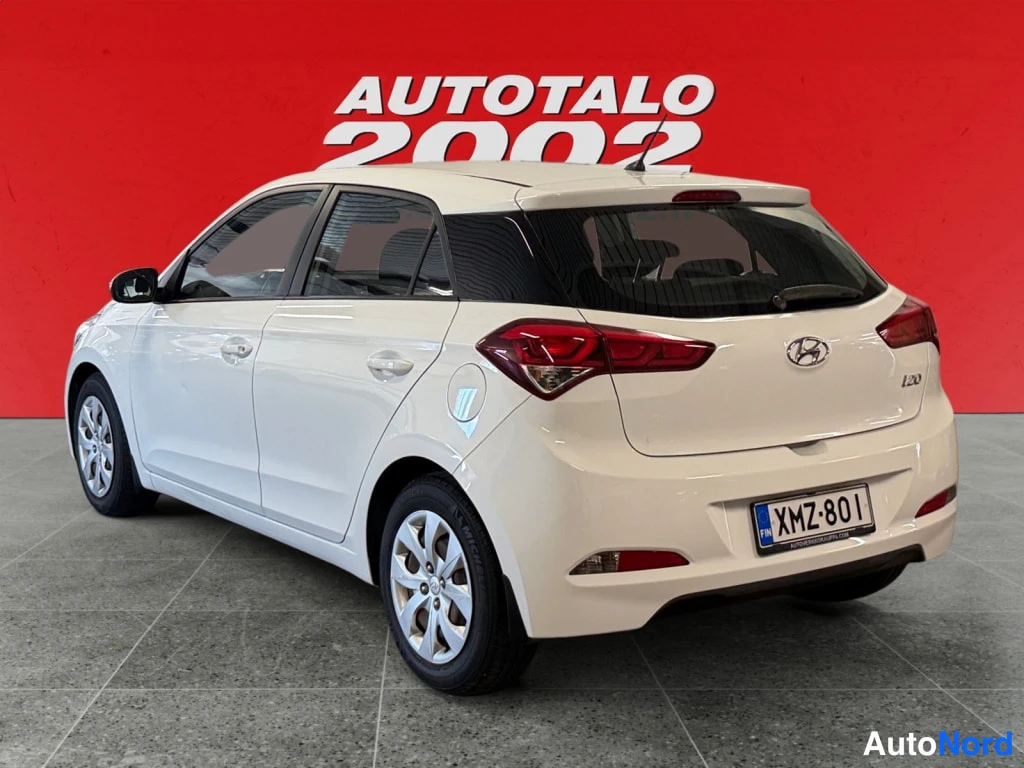 Takaviisto: Valkoisen Hyundai i20:n takakulma vasemmalta sivulta, rekisterikilpi.