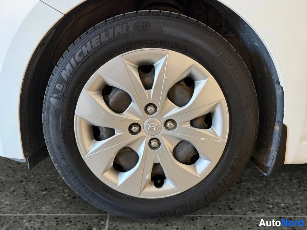 Sivulta: Hyundainhopeavanteen pyörän lähikuva: Michelin-renkuessa lukee MICHELIN ENERGY ja 185/65 R15, puhallusnauha Hyundai-merkki.