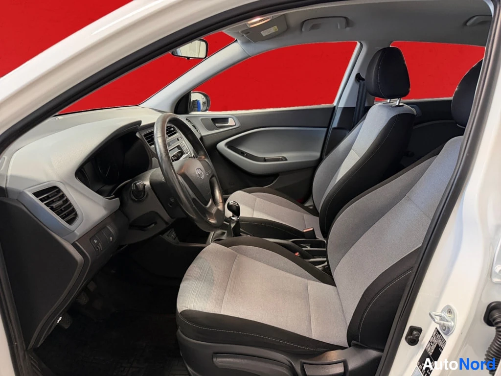 Muu: Auton etuistuimet ja kojelauta kuljettajan puolen oven avatusta sivusta: harmaakangasistuimet, Hyundai-ohjauspyörä ja manuaalivaihteen vaihdekeppi.