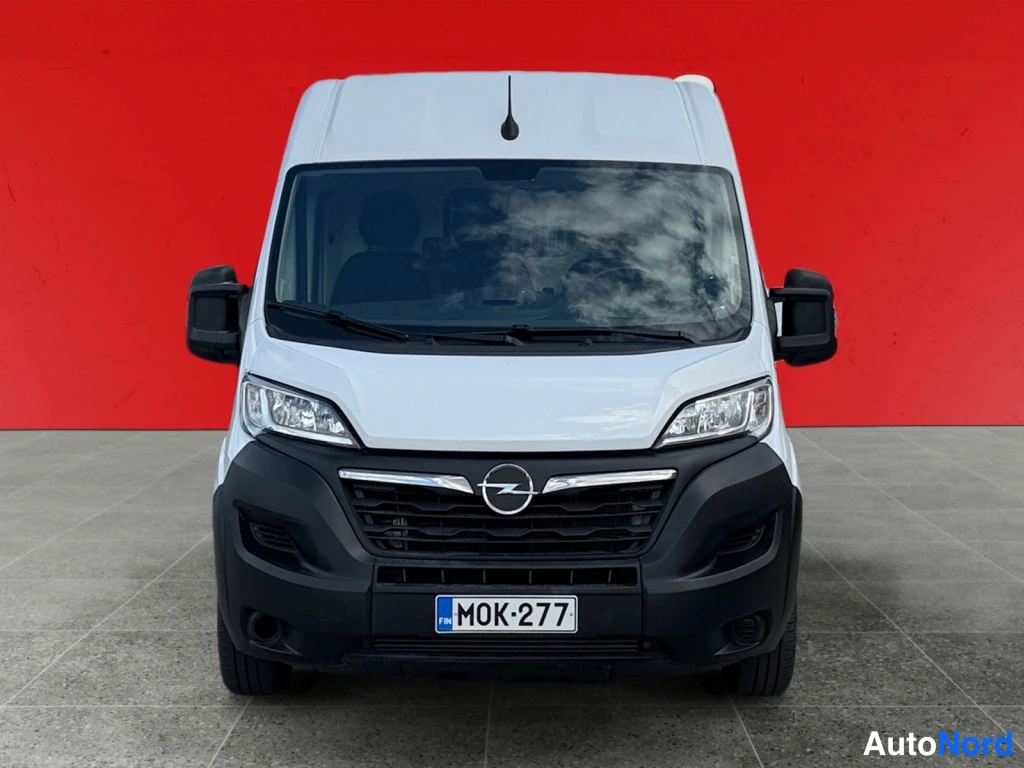 Edestä: Opel Movano -pakettiauton etunäkymä punaisella taustalla, valkoinen koripaneli ja musta etupuskuri.