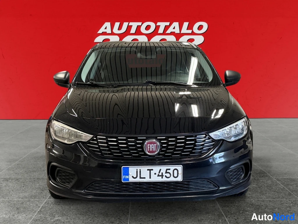 Edestä: Mustan Fiat Tipon etunäkymä: FIAT-merkki säleikössä, rekisteritunnus, sumuvalot puskurissa.