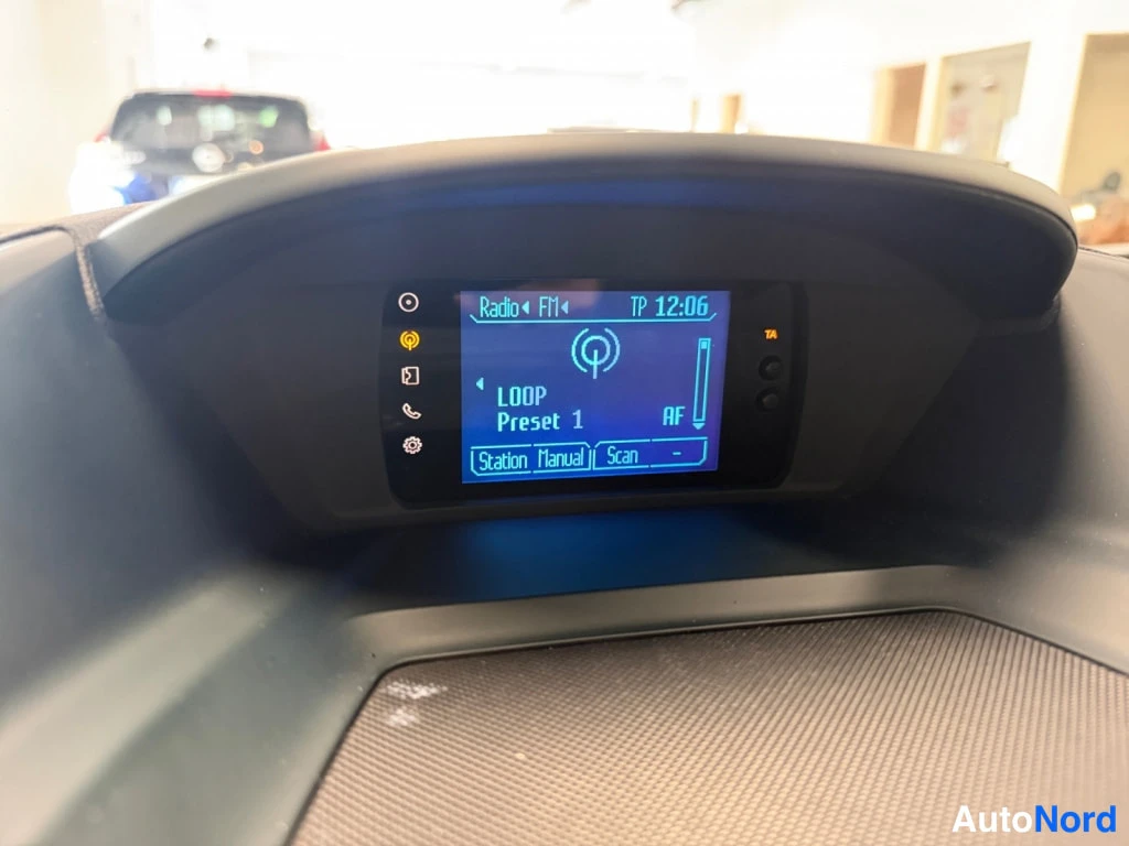 Etuviisto, nokka oikealle: Keskushallinnan näyttö: Radio FM1, TP 12:06, LOOP Preset 1, AF; näytön tiedot tarkistettavissa.