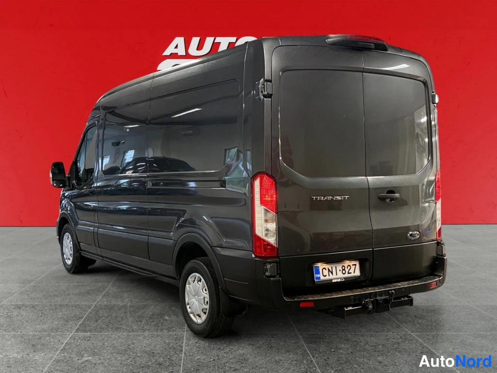 Takaviisto: Ford Transit -pakettiauton takakolmasosakatsaus vasemmalta; takavalot, TRANSIT-teksti ja rekisterikilpi näkyvät.