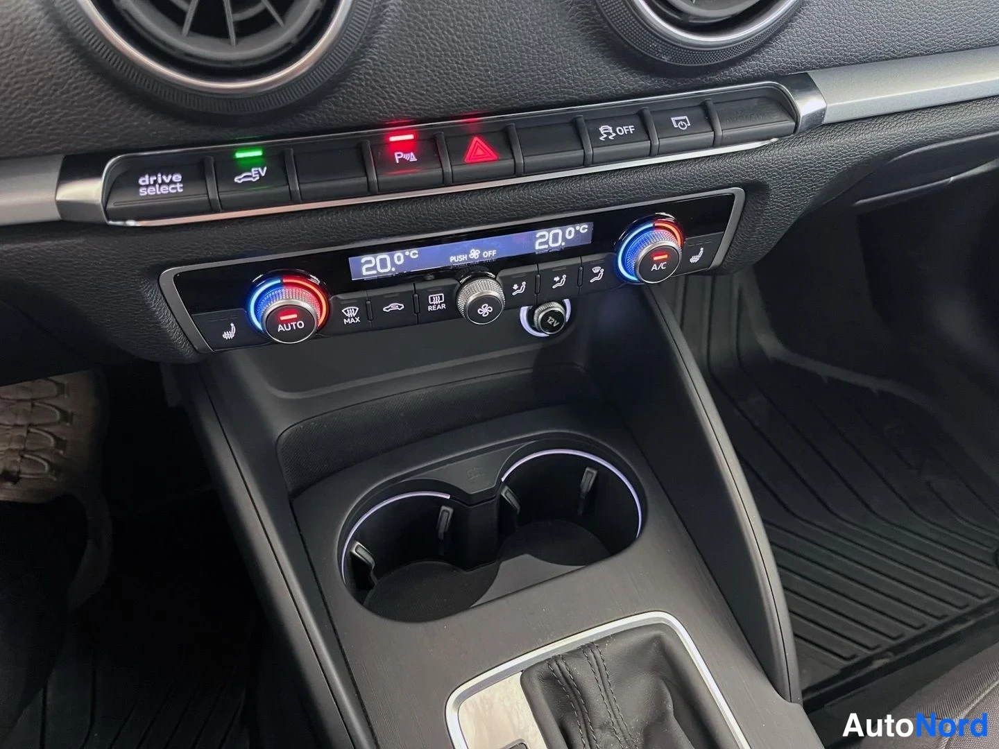 Muu: Audi A3:n kojelaudan keskusta: kaksivyöhykeilmastointi, jonka näytössä lukee 20,0 °C molemmin puolin, drive select -painike, EV-tila, sähköinen parkkirajoitin,