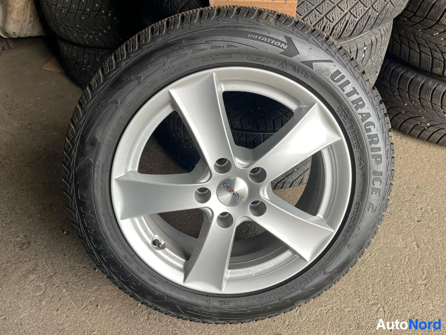 Yksityiskohta: Hopeanvärinen Dezent-vannas Goodyear Ultragrip Ice 2 -talvirengas varastossa