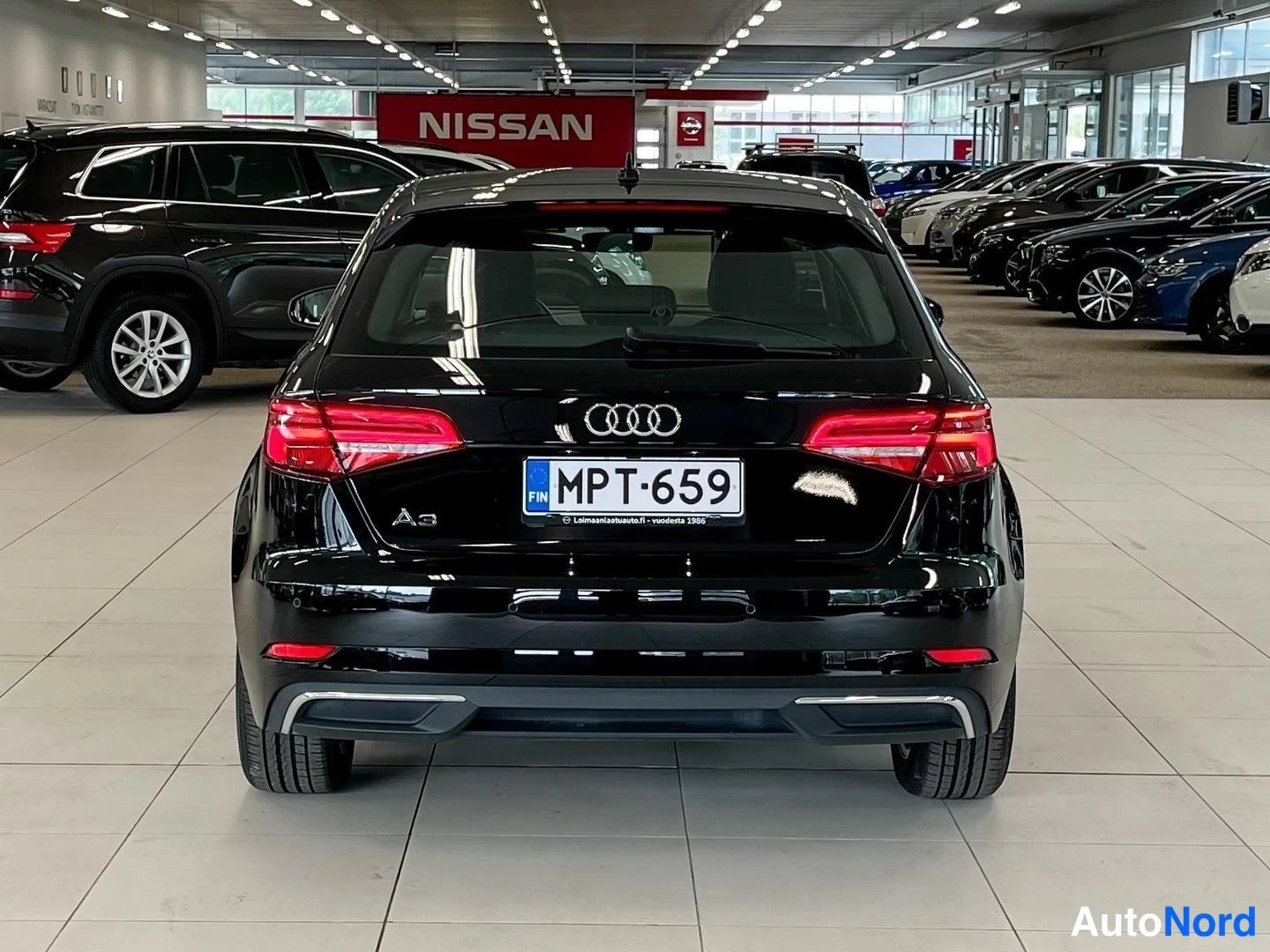 Takaa: Mustan Audi A3:n takanäkyä Autolahden automarketissa; rekisteritunnus.