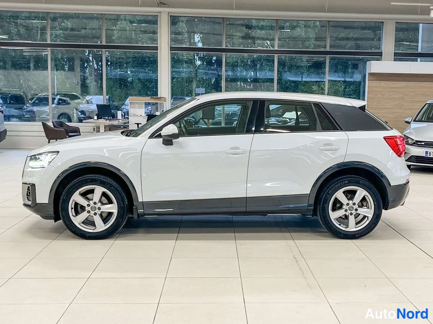 Sivulta: Audi Q2:n sivunäkyväsä valkoinen auto näyttää oikean kyljen siluettia.