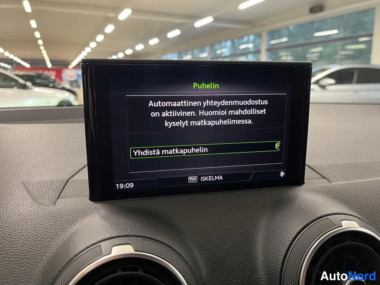 Muu: Kojelaudan näyttö puhelinvalikossa, teksti automaattisesta yhteydenmuodostuksesta ja vaihtoehto Yhdistä matkapuhelin, radion tunnus ISKELMA ja Bluetooth-symboli