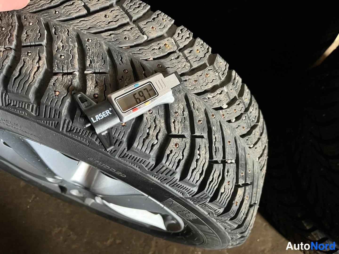 Yksityiskohta: Michelin-nastarenkaan urasyvyys mitataan LASER-merkkisellä urasyvyysmittarilla, jonka näyttö lukee 6,97.