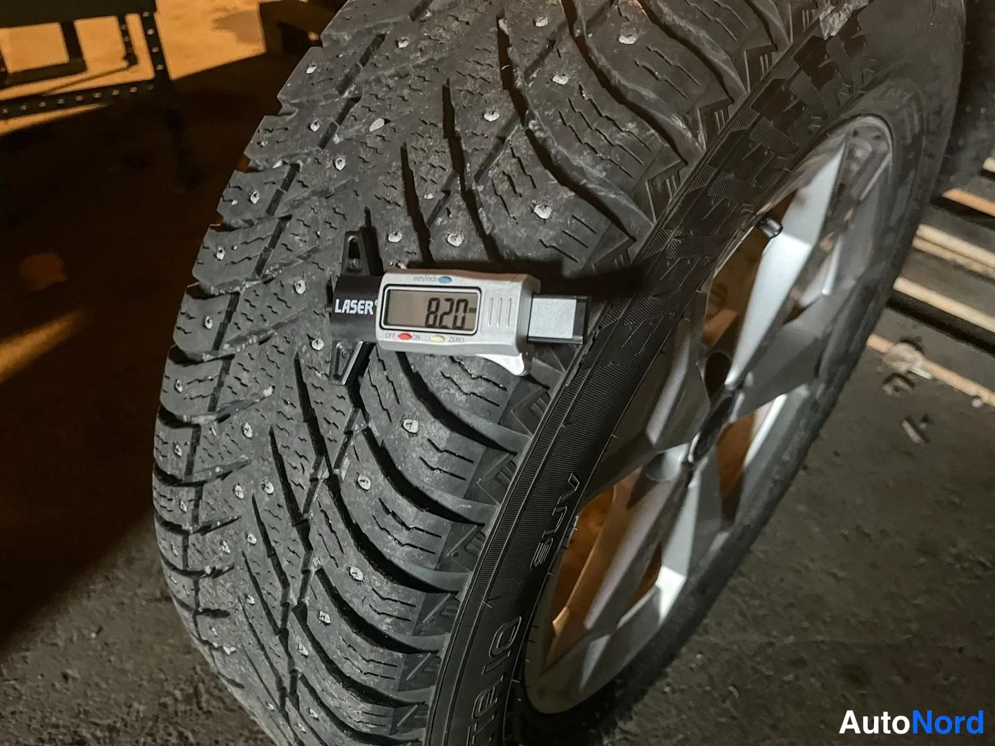 Yksityiskohta: Nastarenkaan urasyvyys mitattu Laser-mittarilla: 8,20 mm. Monea-alumiinivanne näkyy osittain.