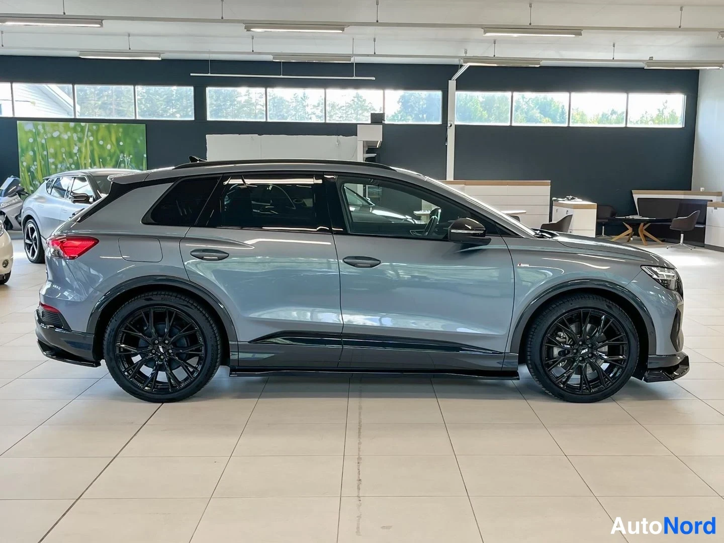 Takaviisto: Audi Q4 e-tron -maasturin takakulmanäkyvää sisätiloissa, harmaan korin ja mustien vanteiden näkyvä.