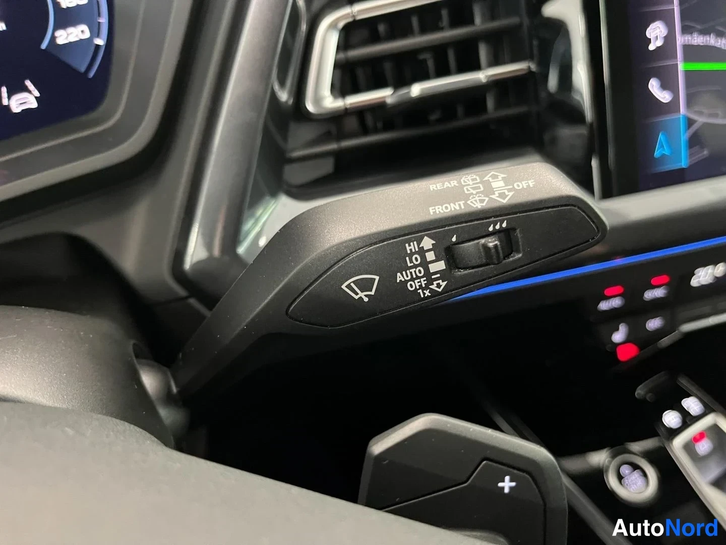 Yksityiskohta: Sisätilakuva: Audi'n tuulilasinpyyhkijöiden vipu, jossa on asennat HI, LO, AUTO, OFF ja 1x, samoin kuin FRONT ja REAR merkinnat.