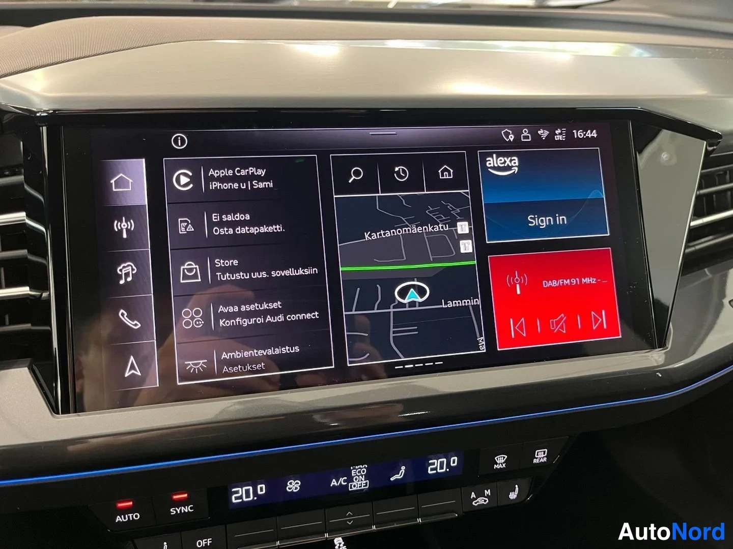 Yksityiskohta: Sisätilakuva: Audi'n keskikonsolin tietoviihdejärjestelmän näyttö Apple CarPlay -valikossa, jossa näkyy mm. 'Apple CarPlay iPhone u | Sami', 'El saldoa', 'Osta