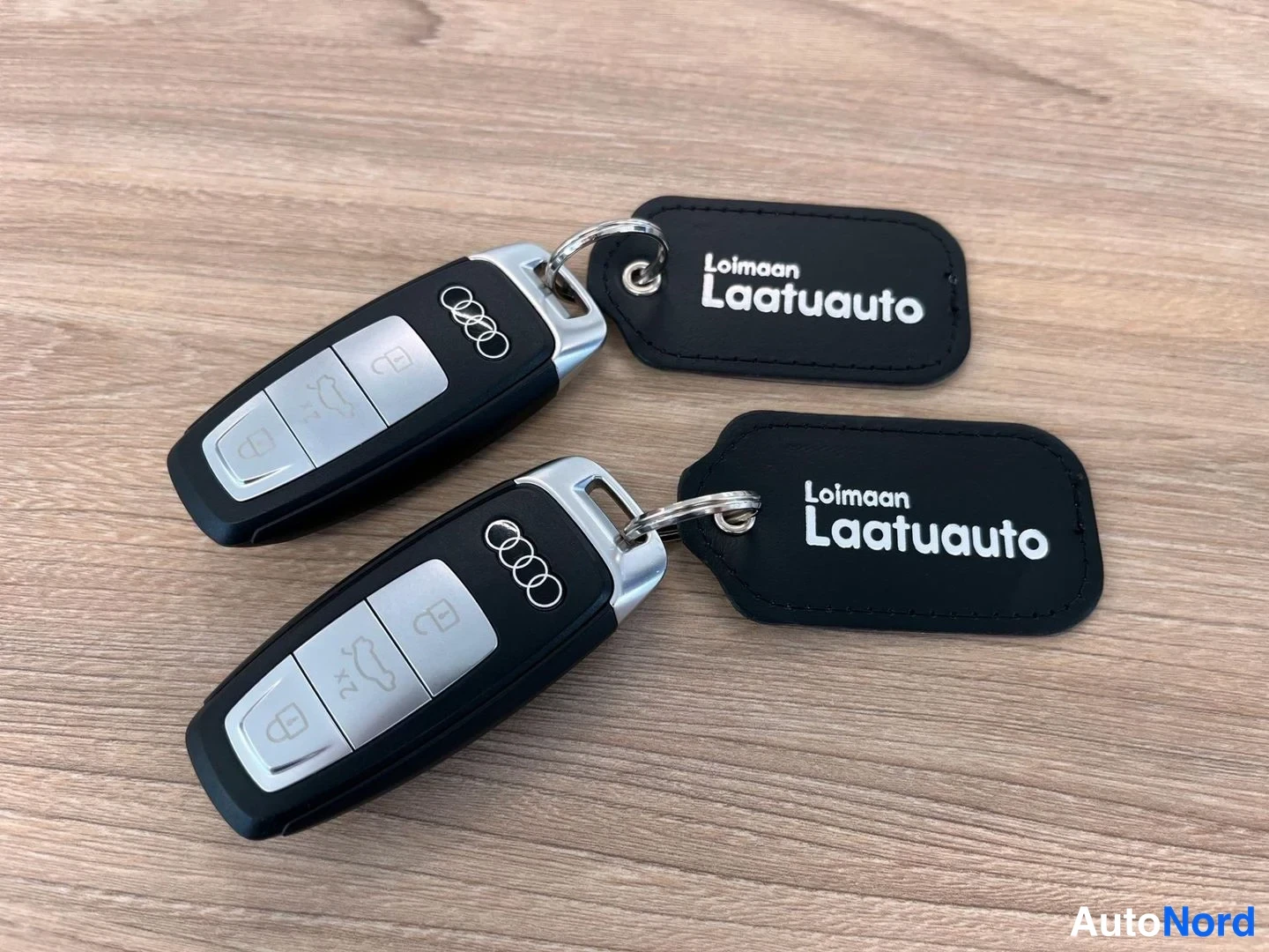 Yksityiskohta: Kaksi Audi-avainpaaria mustilla avainpingillä, joissa teksti Loimaan Laatuauto.