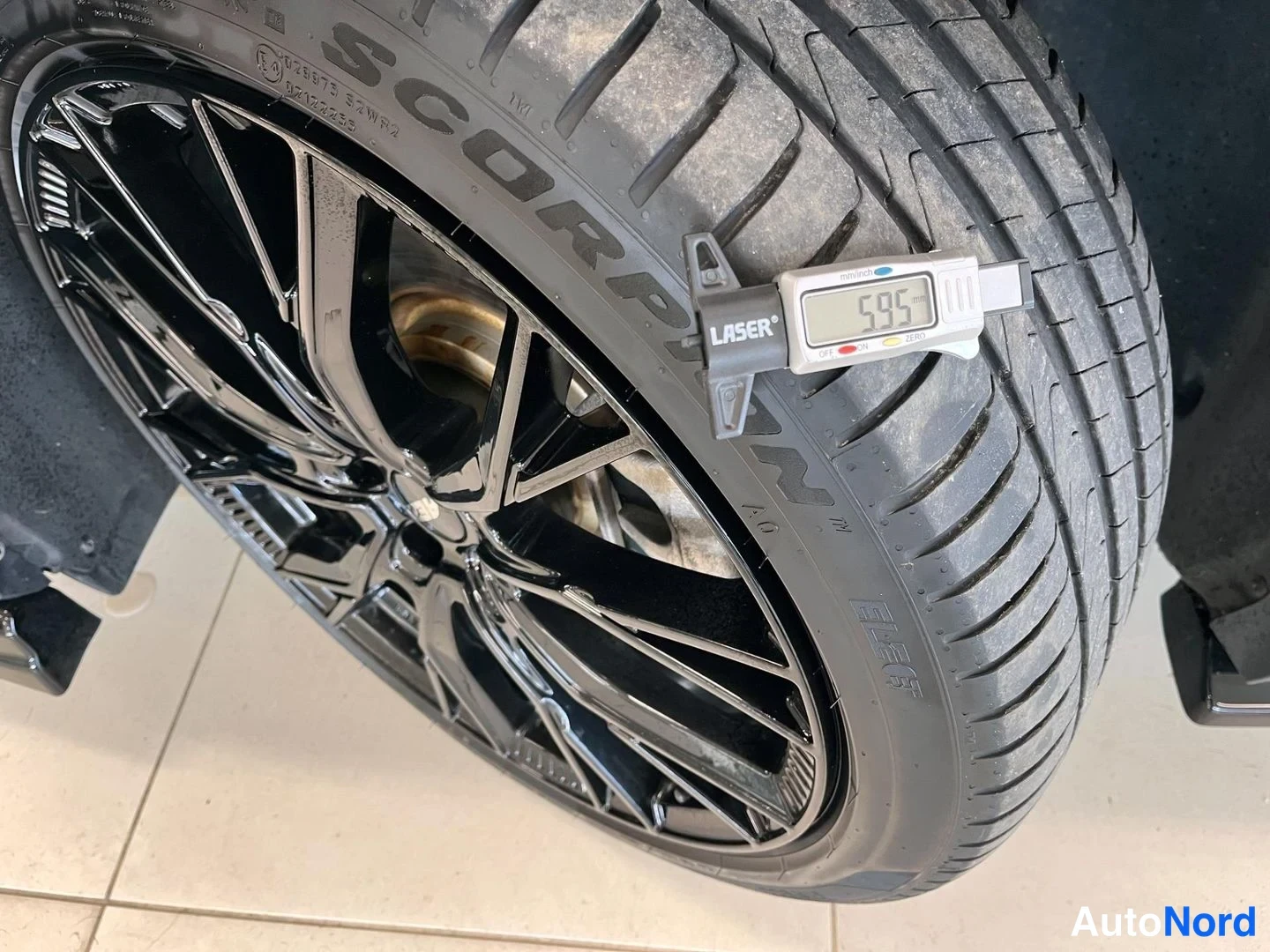 Yksityiskohta: Musta alumiinivanne ja Pirelli Scorpion -renkaan kulku-/urasyvyys mitattu 5,95 mm Laser-mittarilla.