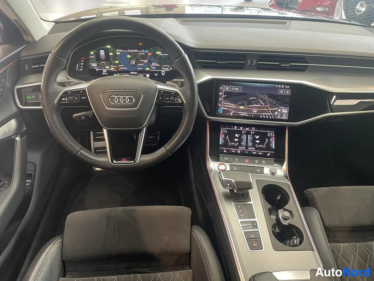 Muu: Audi A6/S6 -mallin ohjaamo: rattia, digitaalisia näyttöjä ja keskikonsolia, mukana navigointi- ja ilmastointinäytöt.