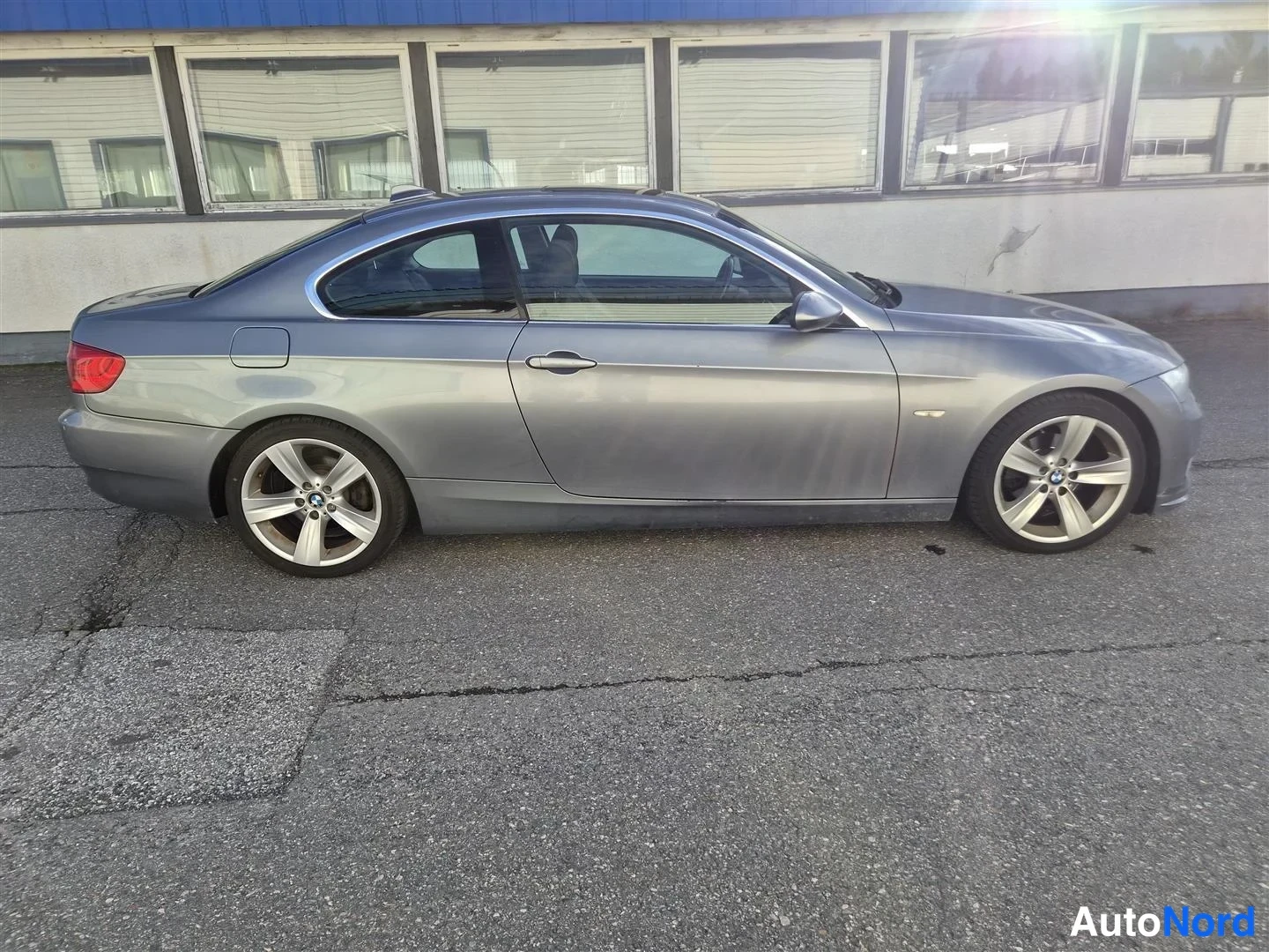 Sivulta: BMW-coupé sivulta vasemmalta, harmaa kori ja metallivanteet.