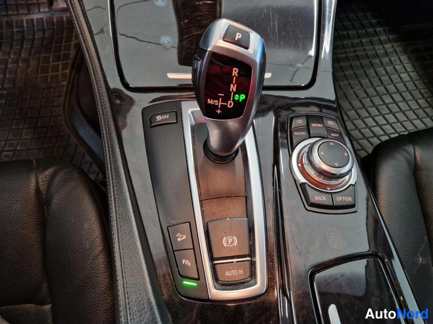 Muu: Kojeistossa automaattivaihteen valitsin P-R-N-D-asemilla ja iDrive-ohjainpaneeli, parkkitutkan ja AUTO H -nappien ympäröimänä.